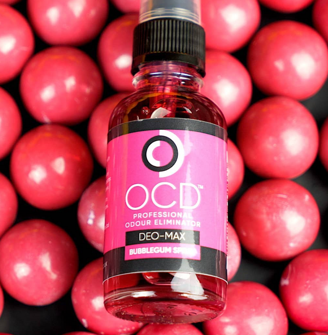 Bottle of OCD Deo-Max Bubblegum Scented product on a background of pink gumballs